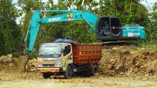 Excavator Excavating Dirt And Top Loading Dump Trucks